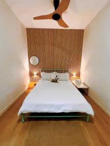 a bedroom with a bed with a ceiling fan at Muji Homestay Ria Heights Tawau in Tawau