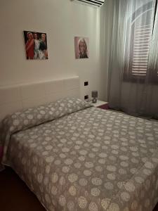 1 dormitorio con 1 cama y 2 cuadros en la pared en LA Tavola Ristorante Pizzeria Da Rino & Figli, en Villaspeciosa