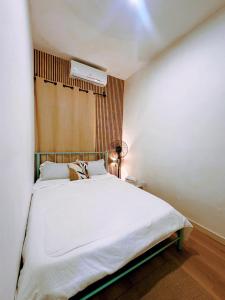 a bedroom with a large white bed in it at Muji Homestay Ria Heights Tawau in Tawau