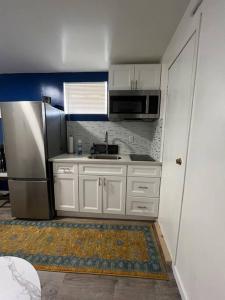 a kitchen with white cabinets and a stainless steel refrigerator at Marvelous Modern apartment at perfect location in Mount Vernon
