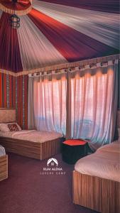 a bedroom with two beds and a canopy at RUM ALIENA LUXURY CAMP in Wadi Rum