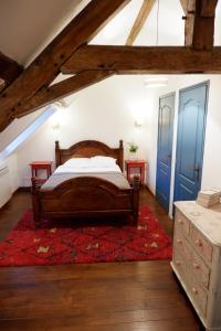 Schlafzimmer mit einem Bett und einem roten Teppich in der Unterkunft Moulin de Petoulle in Charenton sur Cher