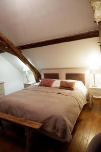 Schlafzimmer mit einem großen Bett mit einem Kopfteil aus Holz in der Unterkunft Moulin de Petoulle in Charenton sur Cher