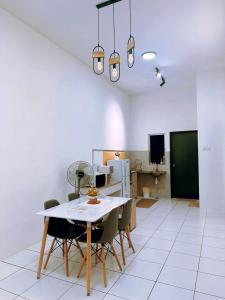 a kitchen and dining room with a table and chairs at Muji Homestay Ria Heights Tawau in Tawau