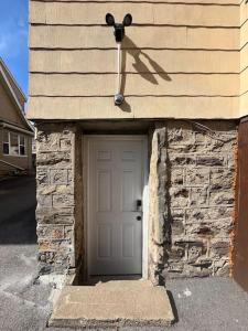 a garage with a white door and a stone wall at Marvelous Modern apartment at perfect location in Mount Vernon