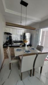 uma cozinha com uma mesa com cadeiras e um balcão em Casa Arraial do Cabo - Figueira em Arraial do Cabo