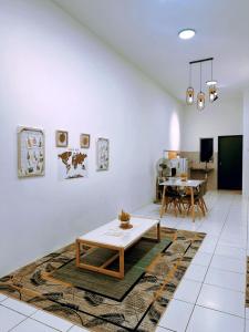 een woonkamer met een tafel en een eetkamer bij Muji Homestay Ria Heights Tawau in Tawau