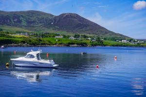 a boat in the water with a mountain in the background at Kilcar Lodge in Kilcar