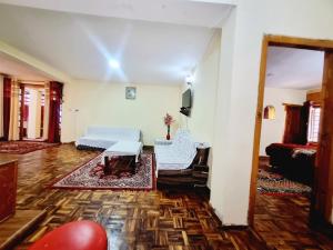 a living room with a bed and a couch at Snow land cottage in Manāli