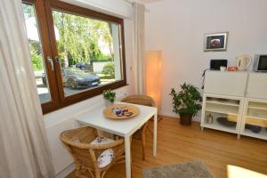 a living room with a table and a window at Moderne Ferienwohnung Deichstrasse in Hennef +4 photos