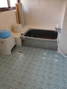 a bathroom with a bath tub and a toilet at 玉の浦sea in Nachikatsuura