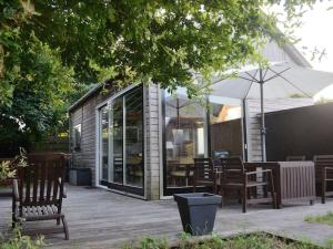 patio con sedie, tavoli e ombrellone di MV8 in Egmond a Egmond-Binnen