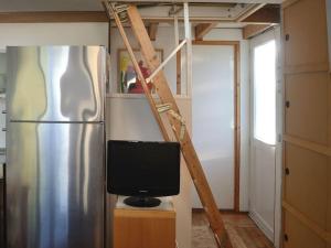 uma cozinha com uma televisão e um frigorífico em MV8 in Egmond em Egmond-Binnen
