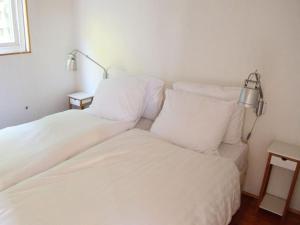 um quarto com 2 camas com lençóis brancos e um candeeiro em MV8 in Egmond em Egmond-Binnen