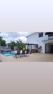 a white house with chairs and a swimming pool at Paradis Spiritain in Saint Esprit