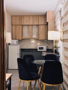 cocina con mesa, sillas y nevera en Montage Apartments en Rāmkot