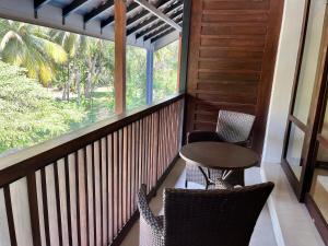 a balcony with chairs and a table and a window at Hotel Randiya Anuradhapura in Anuradhapura