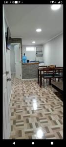 ein Zimmer mit Tischen und Bänken sowie einer Küche in der Unterkunft departamentos mirador 2 piso in Caldera
