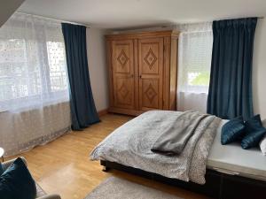 a bedroom with a bed and a wooden cabinet at Wohnung mit Dachterasse in Absberg
