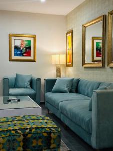 un soggiorno con 2 divani blu e un tavolo di Montage Apartments a Rāmkot