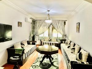 a living room with couches and a table at Sary's Hotel in M'diq
