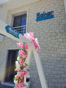 切什梅Bahar Butik Otel的建筑前的白色十字架,花粉红色