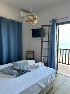 a bedroom with a bed with a view of the ocean at Amelia Beach Apartments in Agios Ioannis Pelio