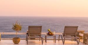two chairs and a table with a view of the ocean at Atlantis Beach Residence in Super Paradise Beach