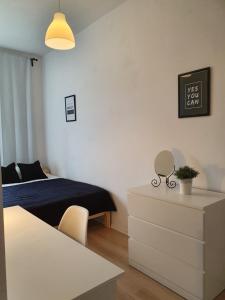1 dormitorio con cama, tocador y mesa en Pokoje u Mareczka, en Gdynia