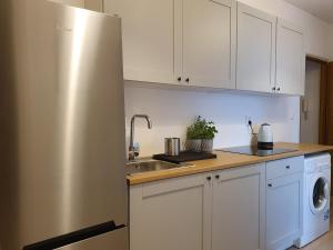 a kitchen with white cabinets and a stainless steel refrigerator at Pokoje u Mareczka in Gdynia