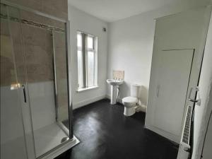 y baño con ducha de cristal y aseo. en Comfortable Room in Shared Sheffield Detached House - Room 3, en Neepsend