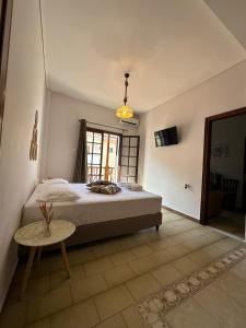 Schlafzimmer mit einem Bett, einem Tisch und einem Fenster in der Unterkunft Amelia Beach Apartments in Agios Ioannis