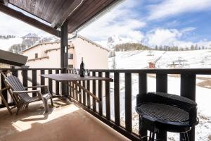 einen Balkon mit einem Tisch und Stühlen sowie schneebedeckten Bergen in der Unterkunft Echo des marmottes - Terrasse - Barbecue - Parking in Enchastrayes
