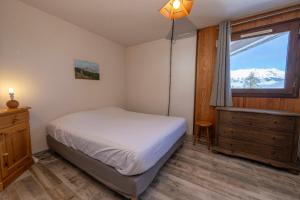 um quarto com uma cama e uma janela em Echo des marmottes - Terrasse - Barbecue - Parking em Enchastrayes