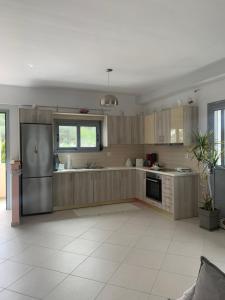a kitchen with wooden cabinets and a stainless steel refrigerator at For a good hospitality in Souvala