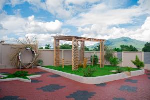 an outdoor pergola with a table on a lawn at Ladari Apartments in Babati