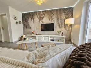 a living room with a couch and a tv on a wall at Ferienhaus am Stadtpark, 3 Schlafzimmer, Wozi mit Bett und Schalfsofa,Businesswohnung, Monteurezimmer in Salzgitter