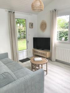 a living room with a couch and a tv at La Palaine, maison à 150m de la mer in La Plaine-sur-Mer