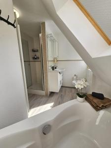 a white bathroom with a sink and a bath tub at Ferienhaus am Stadtpark, 3 Schlafzimmer, Wozi mit Bett und Schalfsofa,Businesswohnung, Monteurezimmer in Salzgitter +6 photos