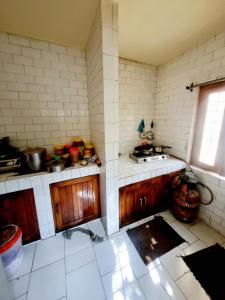 una cocina con armarios de madera y fregadero en Snow land cottage en Manāli