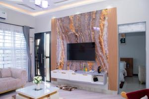 sala de estar con TV en la pared en Ladari Apartments en Babati