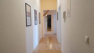 a hallway with several pictures on the walls and a hallway with a hallway at Kienreich Apartments Görlitzer Innenstadt in Görlitz