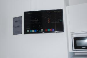 Ein Fernseher hängt an der Wand neben einer Mikrowelle. in der Unterkunft Studio Busho in Naoussa