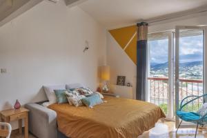 um quarto com uma cama e uma grande janela em Casa Semaphore em L'Île-Rousse