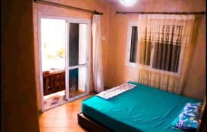Jawharat Mekkad في Oued Laou: غرفة نوم بسرير اخضر ونافذة
