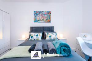 a bedroom with a bed with blue blankets on it at Weekly Stay By NYOS PROPERTIES Short Lets & Serviced Accommodation Manchester With Free parking in Manchester