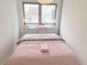 a bed with a pair of slippers on it in a room at City center flat with balcony & free parking in Oslo