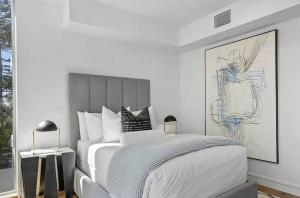 um quarto branco com uma cama e um desenho na parede em Three Bedrooms and Four Bathrooms Superb Condo em Los Angeles