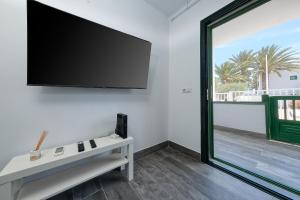 un salon avec une télévision à écran plat sur un mur dans l'établissement Casa Emilia-close to amenities and the beach, à Puerto del Carmen