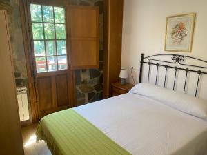 a bedroom with a bed with a green and white blanket at Hotel Rural Camino Medulas in Ponferrada